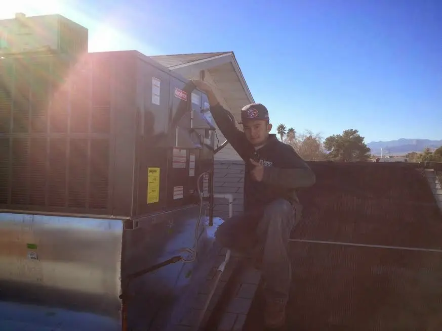 HVAC technician performing Boiler Repair on a rooftop unit in Laketon